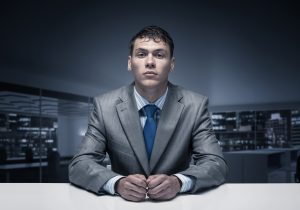 Nervous man sitting at interview table.